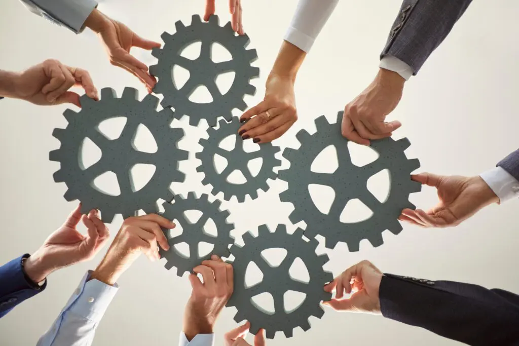 handsfromdiverseindividualsworktogethertoarrangelargegears